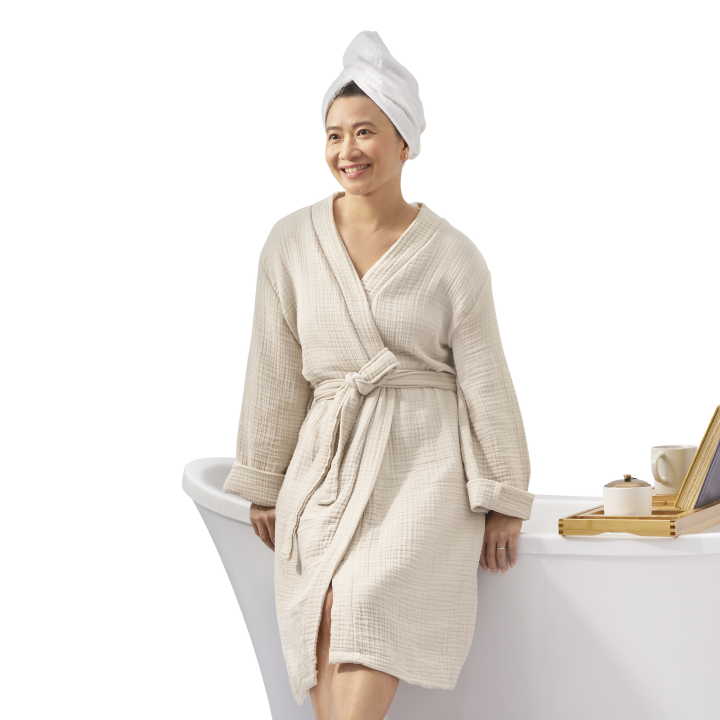 middle aged Asian woman smiling leaning on her brand new bathtub